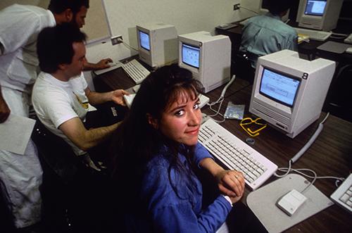 Student smiling in front of 1990s computer